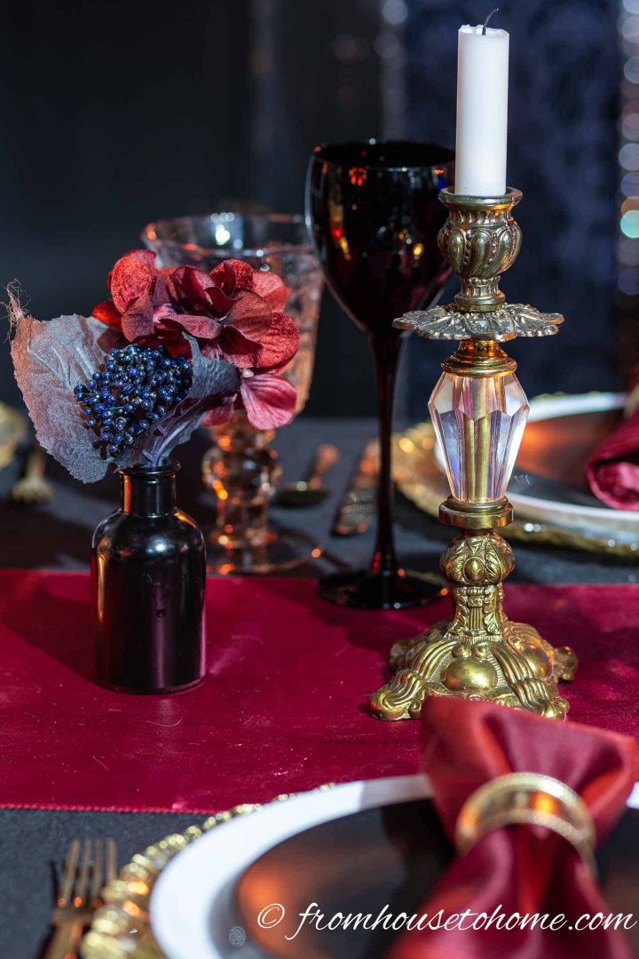 Small black vase with flowers and a vintage gold candlestick