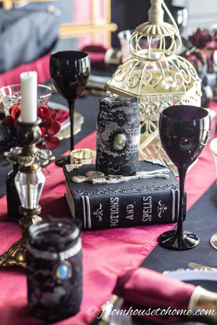 Halloween centerpiece with black candles, black wine glasses and a red runner