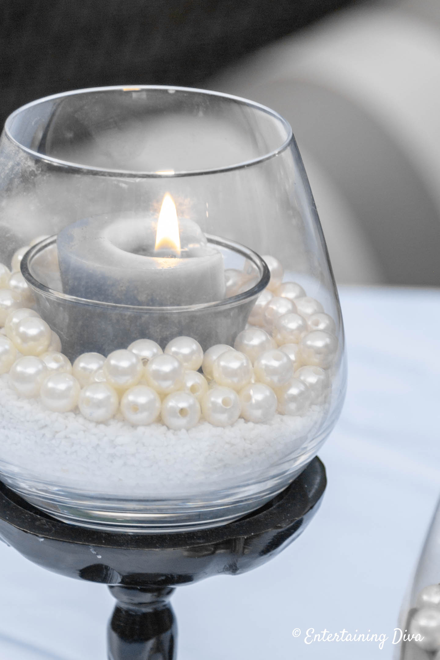 Grey votive candle in a sand and faux pearls candle holder