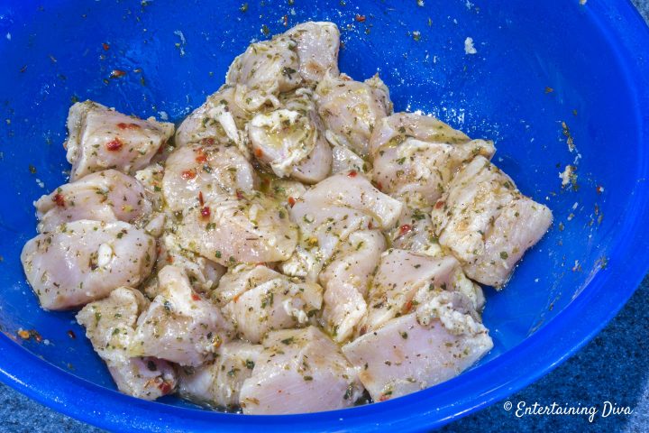 Cubes of chicken marinating in a bowl