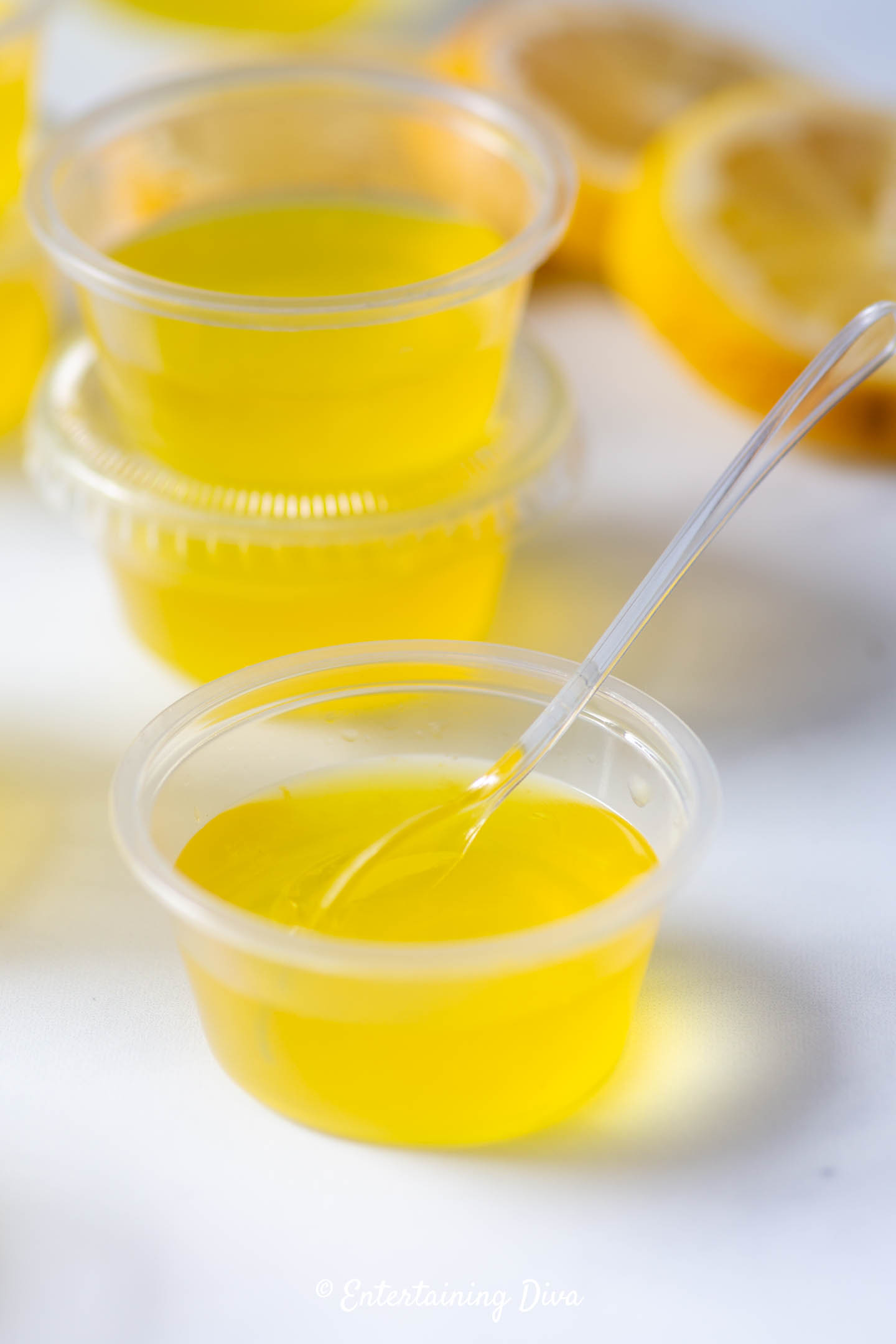 Lemon drop jello shots recipe in a jello shot cup with a mini tasting spoon Lemon drop jello shots recipe in a jello shot cup with a mini tasting spoon