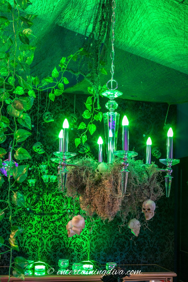 Maleficent party forest decor with green lights and Spanish moss draped on a chandelier