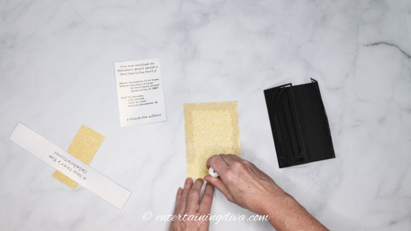 Gluing the gold glitter cardstock for the DIY Great Gatsby party invitation
