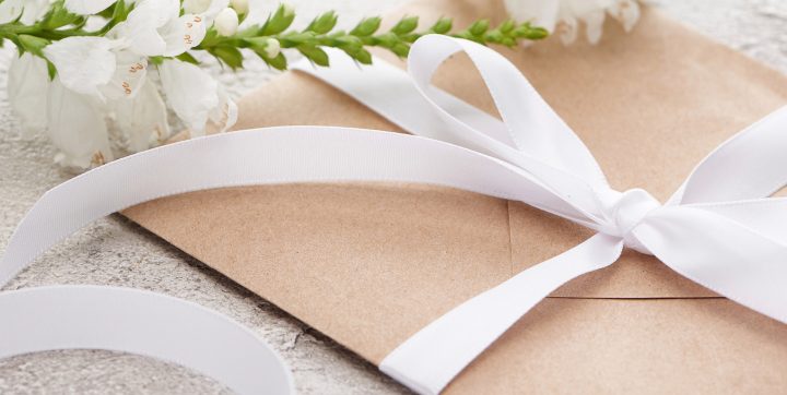 Invitation envelope wrapped in a bow