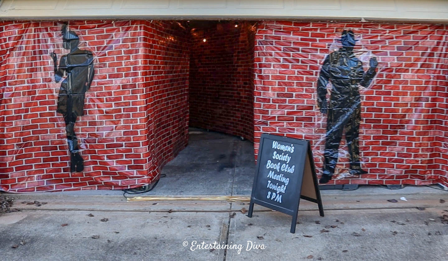 Speakeasy party entrance decor with a red brick scene setter and black gangster scene setters