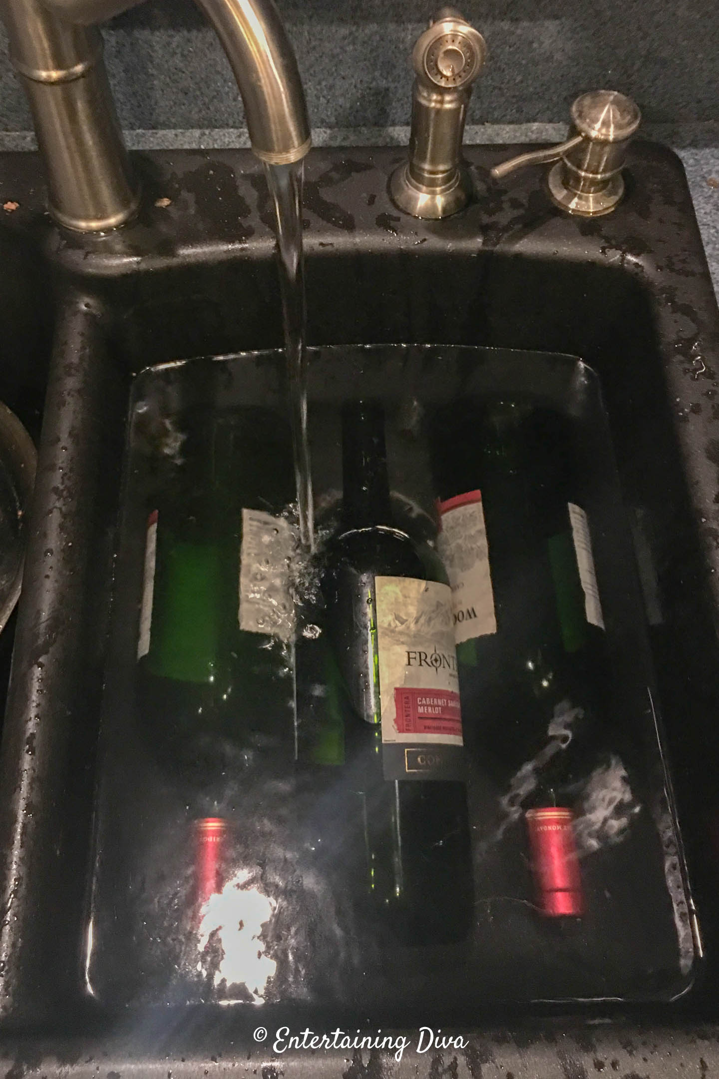 wine bottles soaking in water in the sink