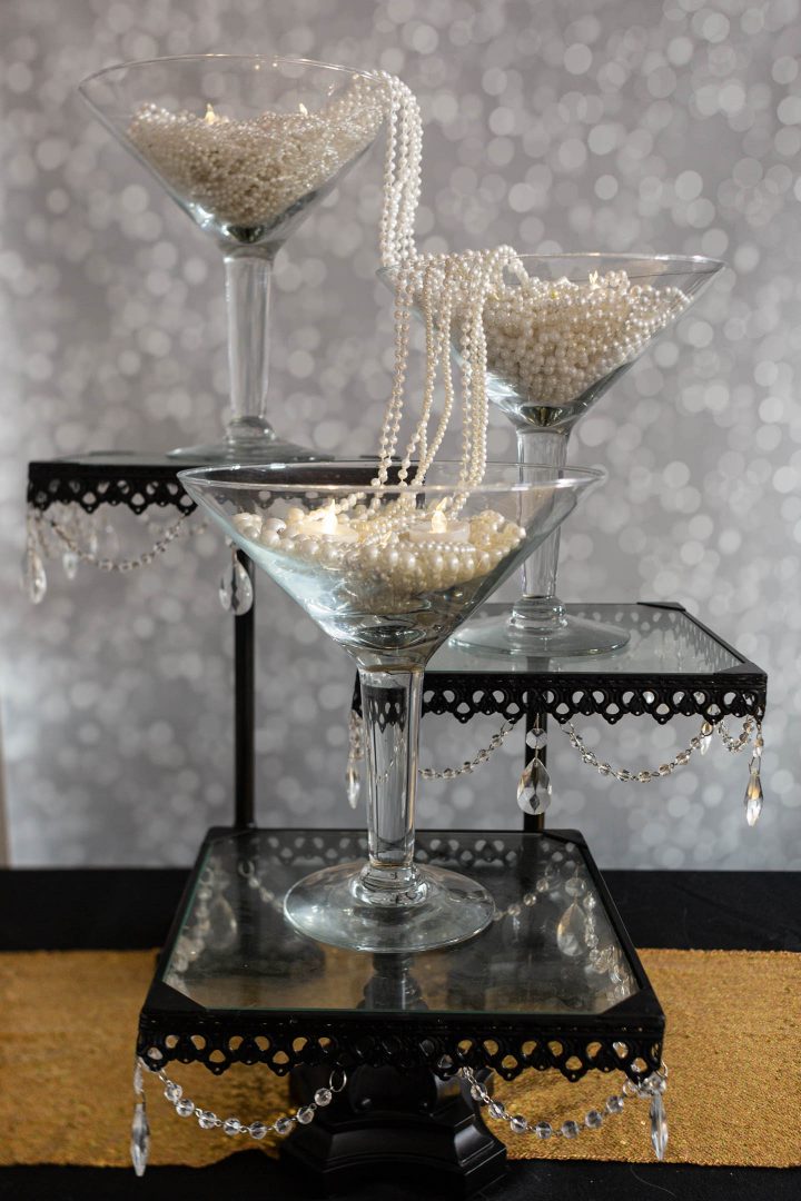 Great Gatsby centerpiece made with large martini glasses and strings of faux pearls
