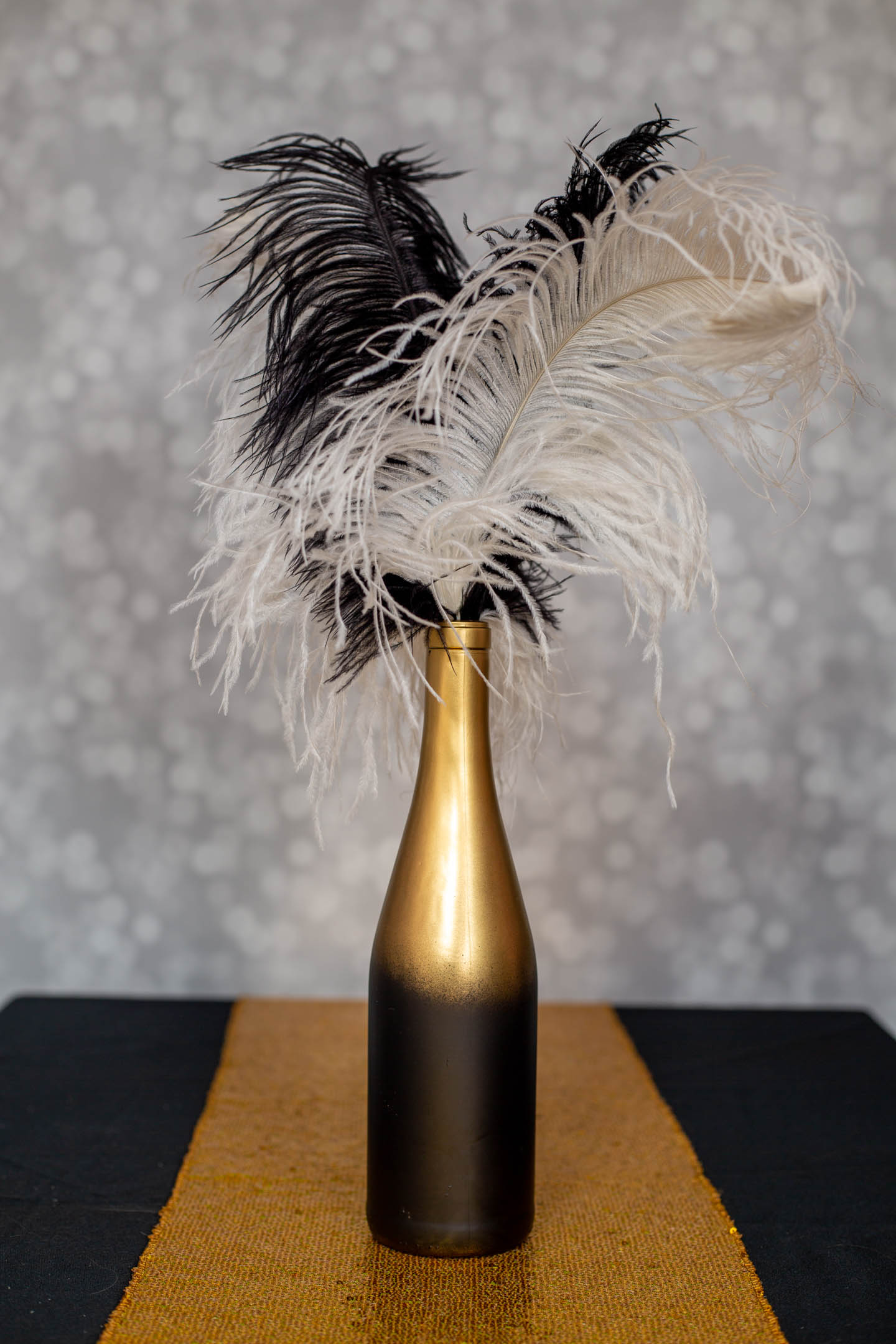 Small Great Gatsby centerpiece made with ostrich feathers and a wine bottle