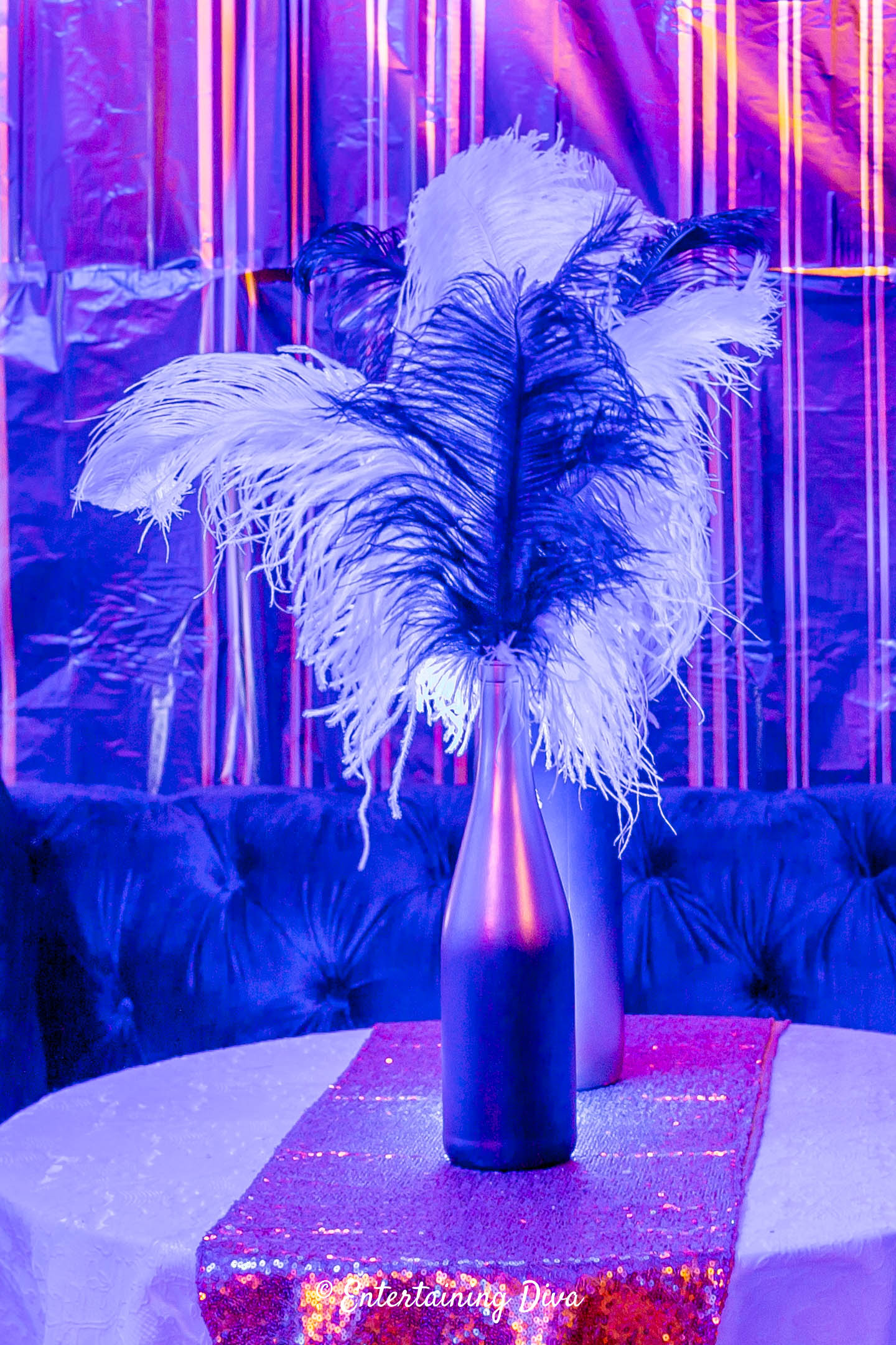 Wine bottle ostrich feather Great Gatsby centerpieces on a party table