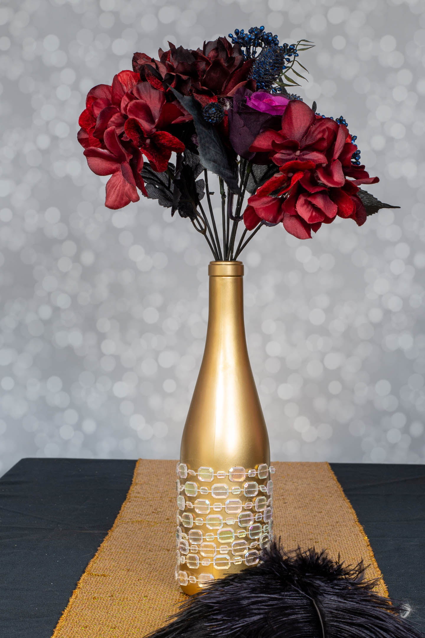 Embellished wine bottle with a faux flower arrangement