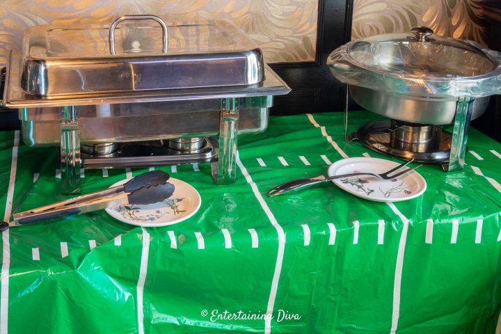 Serving utensils in front of chafing dishes on a buffet
