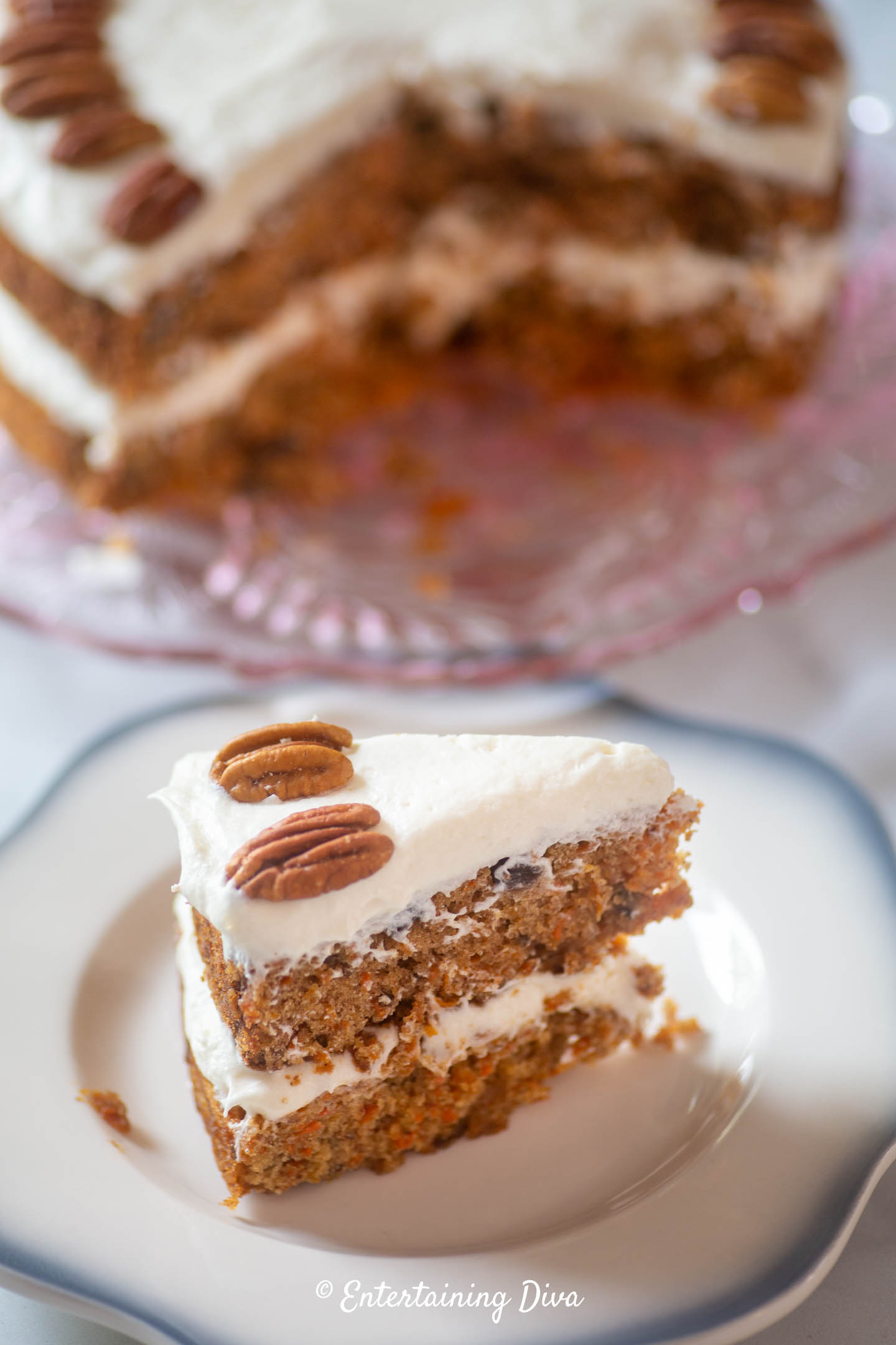 A piece of a 2-layer carrot cake with cream cheese frosting on a plate
