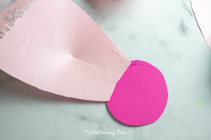 Where to put the glue to attach additional petals to the paper flower