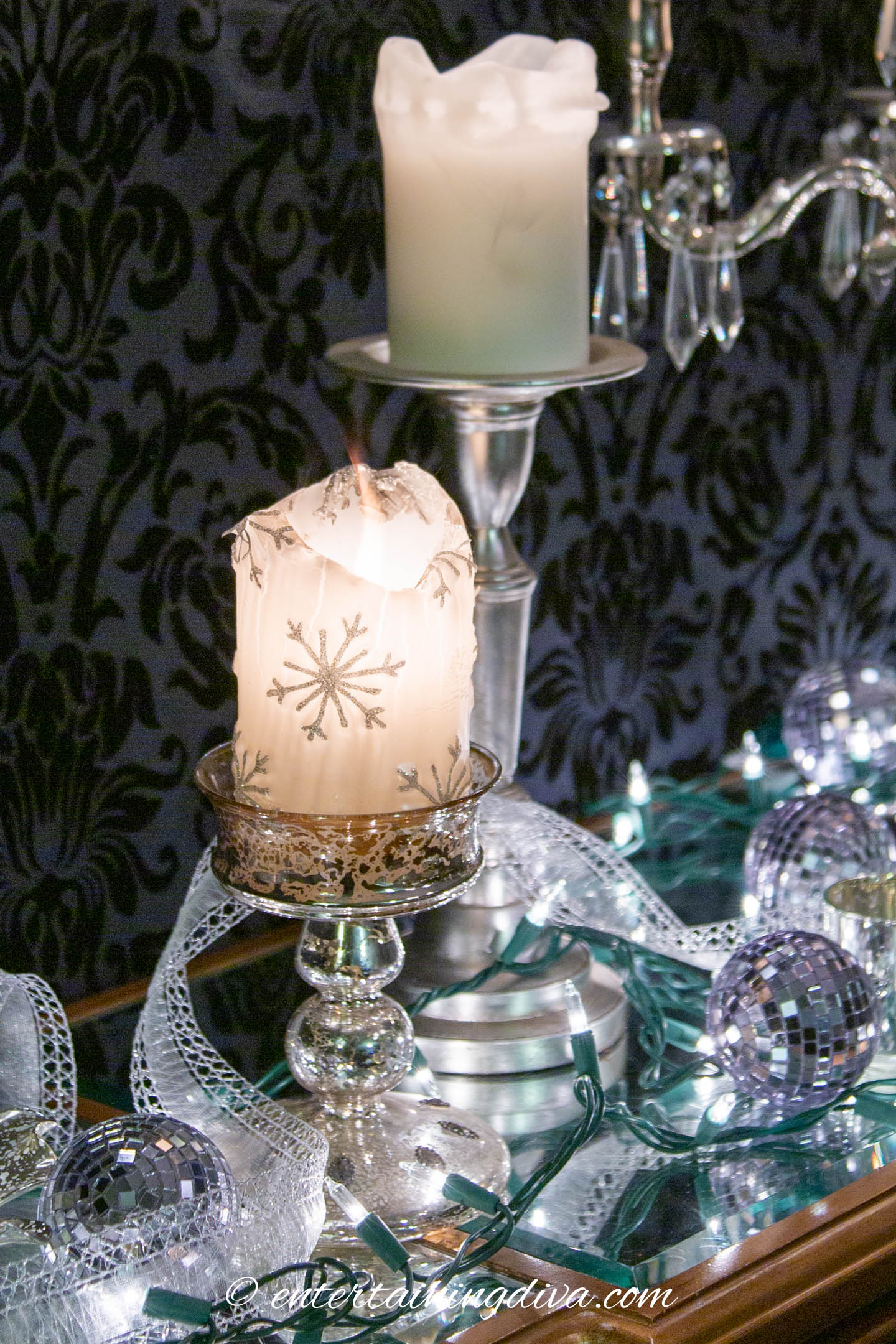 White candles, lights and ornaments used as Christmas decorations on a buffet