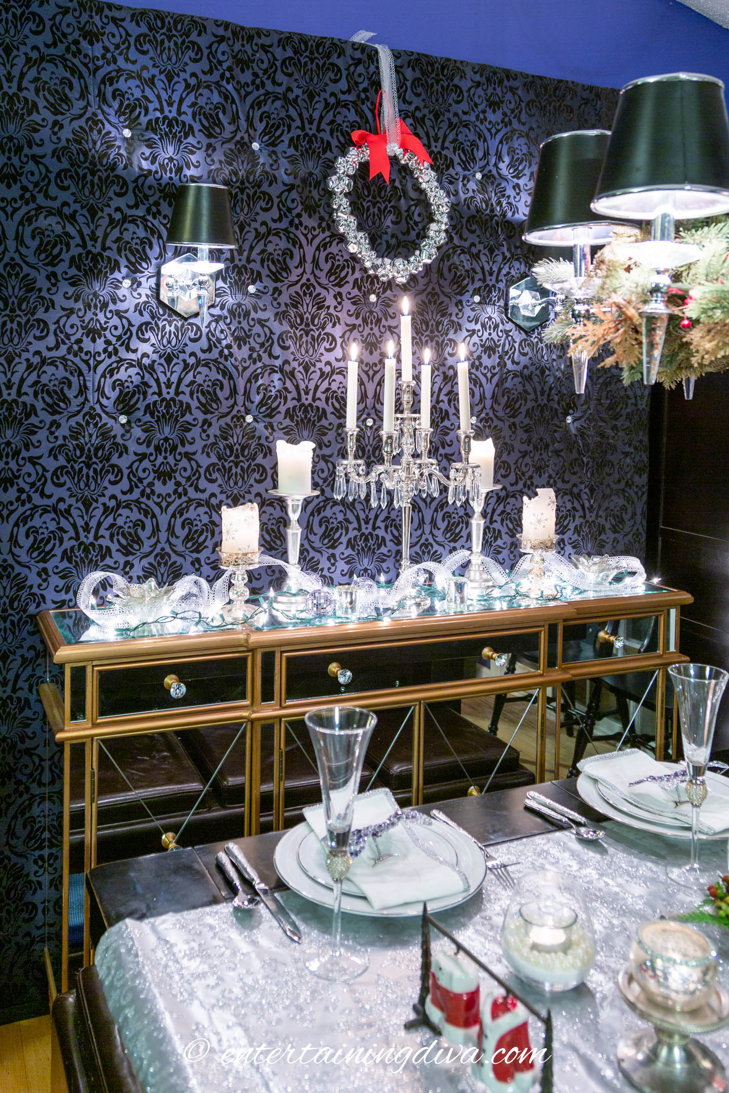 Silver wreath hung over a buffet decorated for Christmas