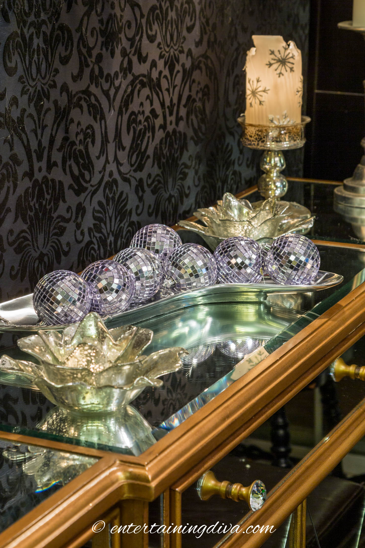 Tray filled with mirror ball Christmas ornaments on a buffet