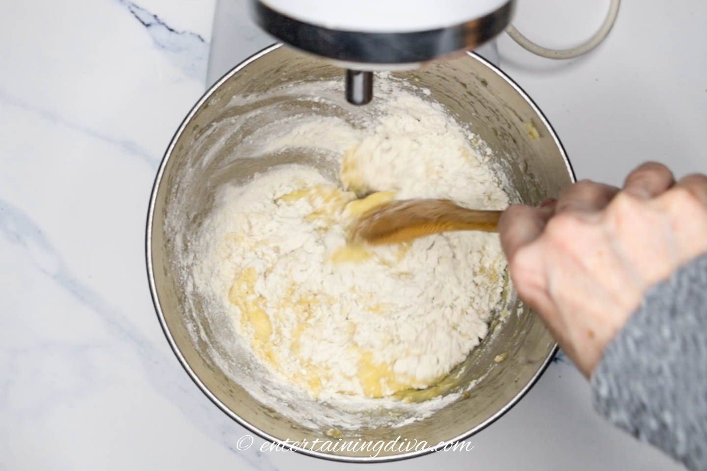 Banana nut bread dry ingredients added to wet ingredients in mixing bowl