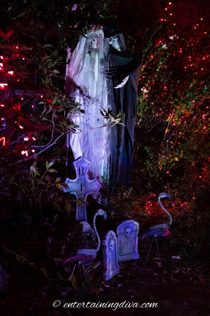 Bride and groom ghosts lit up at night in the Halloween cemetery