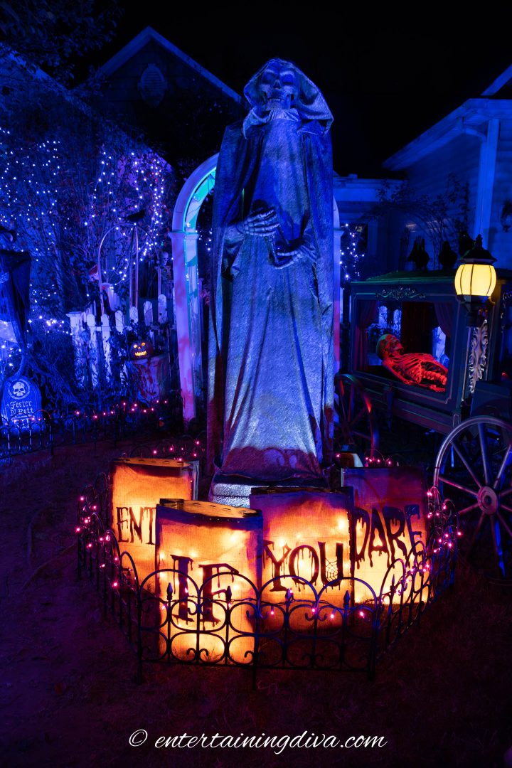 Large Halloween grim reaper statue lit up at night