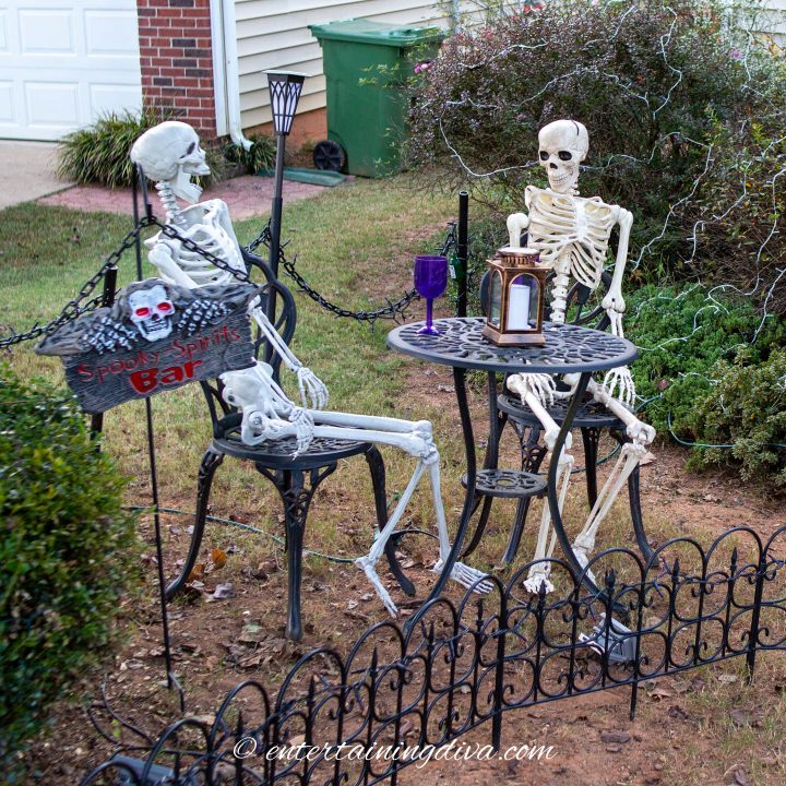Skeletons sitting at an outdoor  table