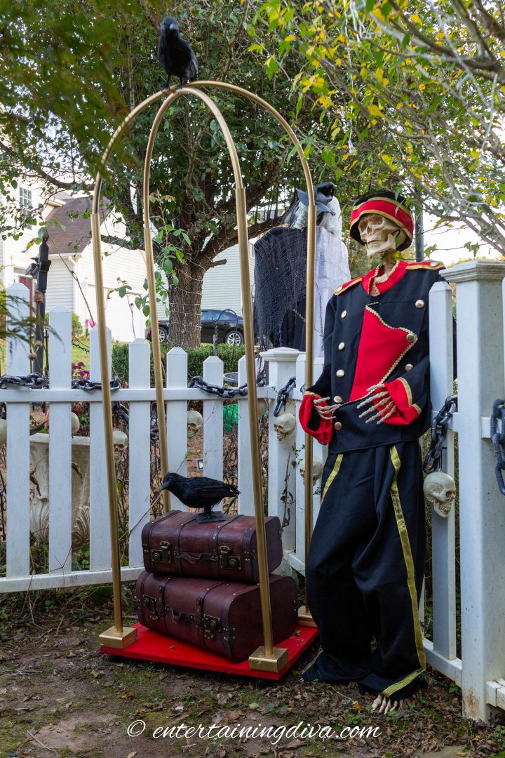 DIY luggage cart with suitcases and a skeleton wearing a bell boy costume