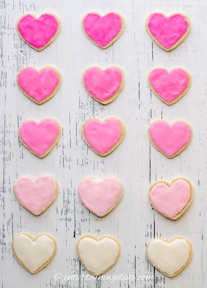 heart cookies frosted with different shades of pink royal icing