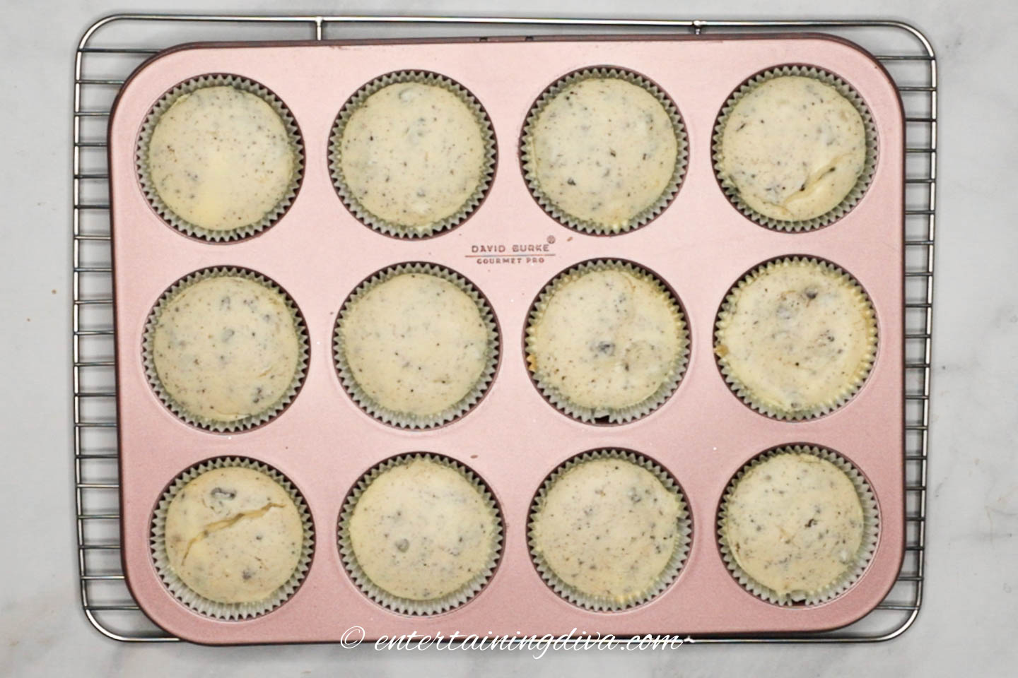 Baked Oreo cheesecake cupcakes in the tin on a cooling rack