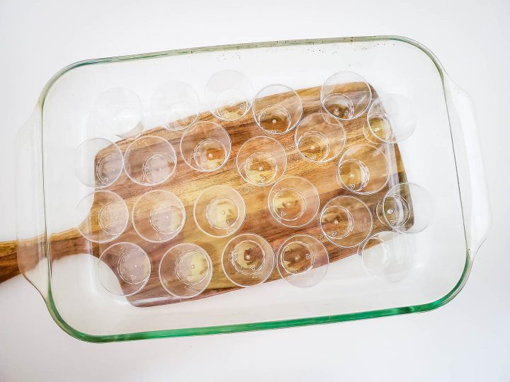 empty jello shot cups in a shallow baking dish