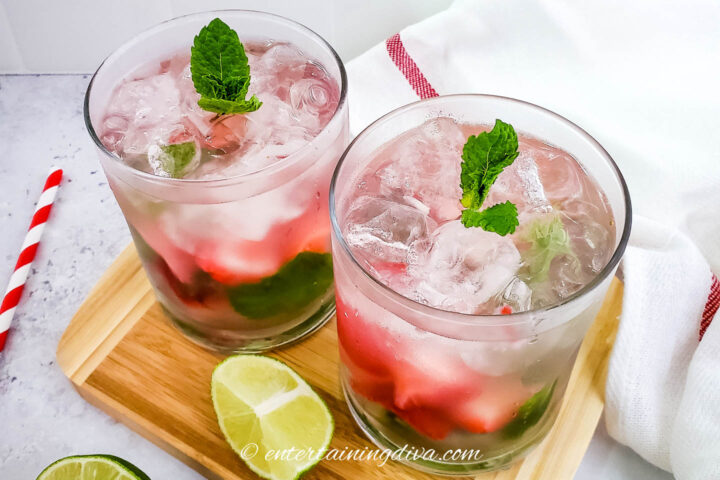 Two strawberry mojitos on a cutting board