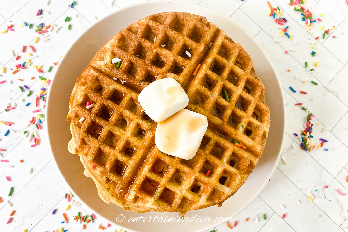 top view of waffles on plate with butter and sprinkles