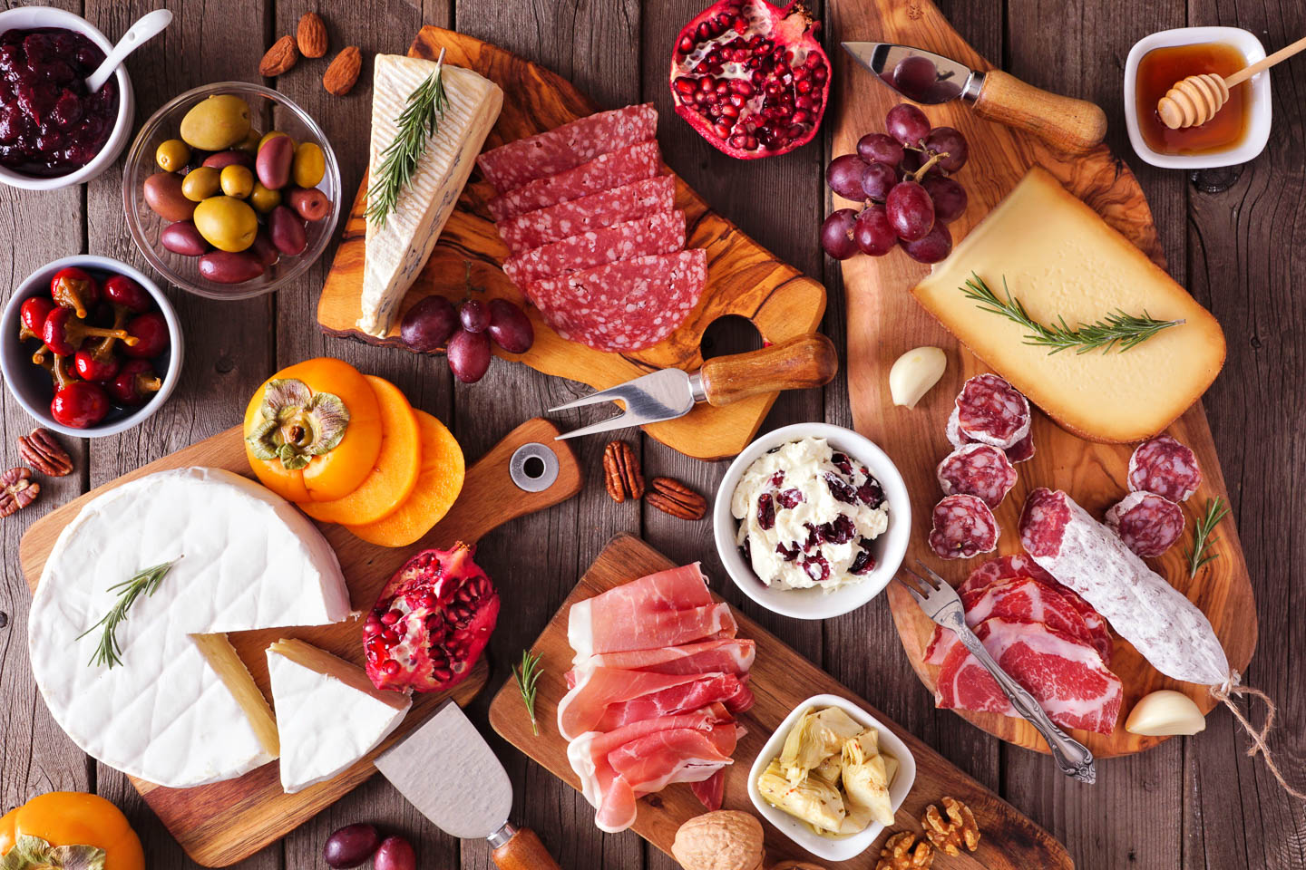 Deconstructed charcuterie board with multiple cutting boards and bowls making up the display