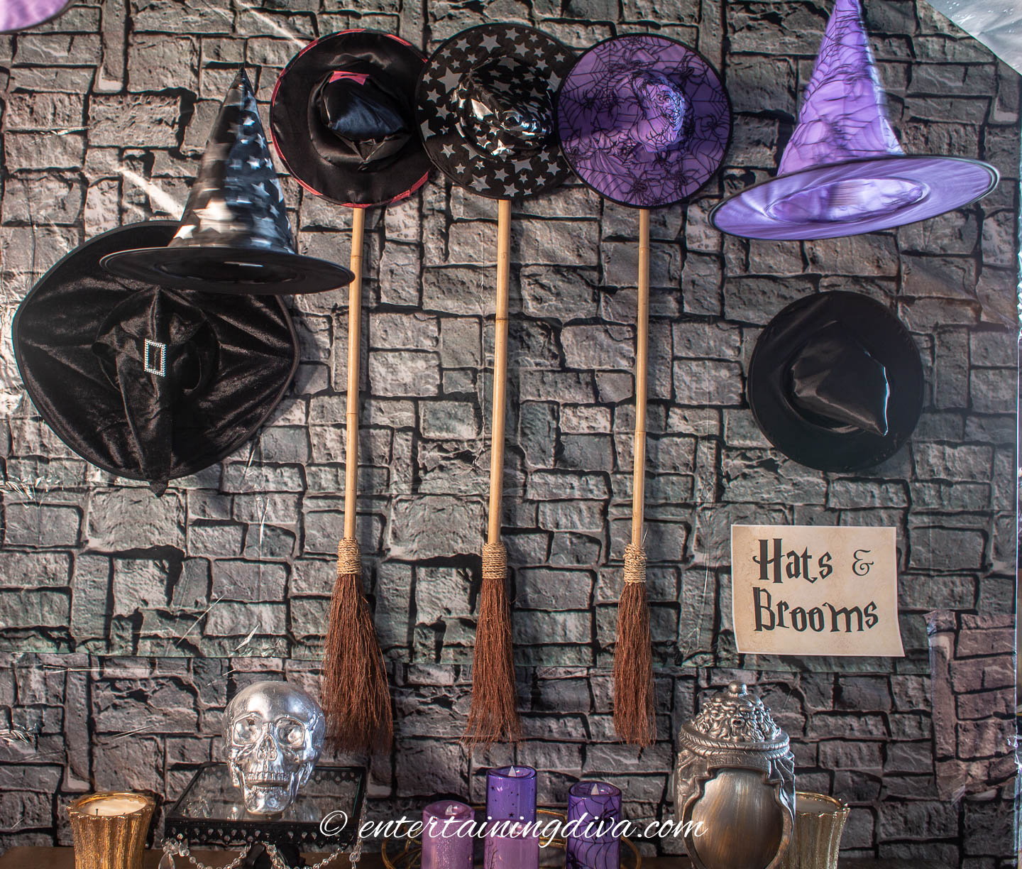 Watches hats and broomsticks hanging on the wall at a witches Halloween party