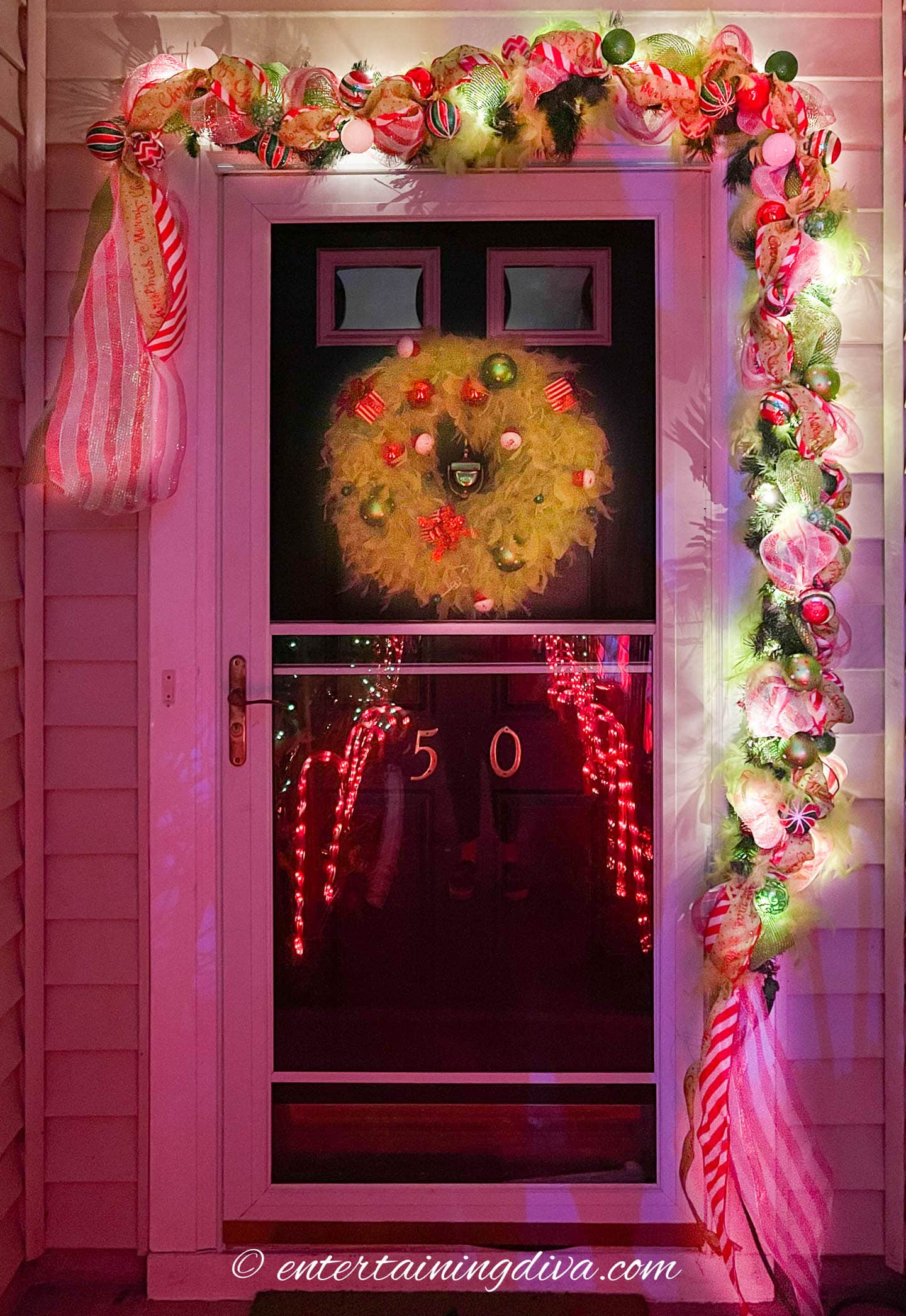 DIY Grinch garland with lights on it hanging over the door