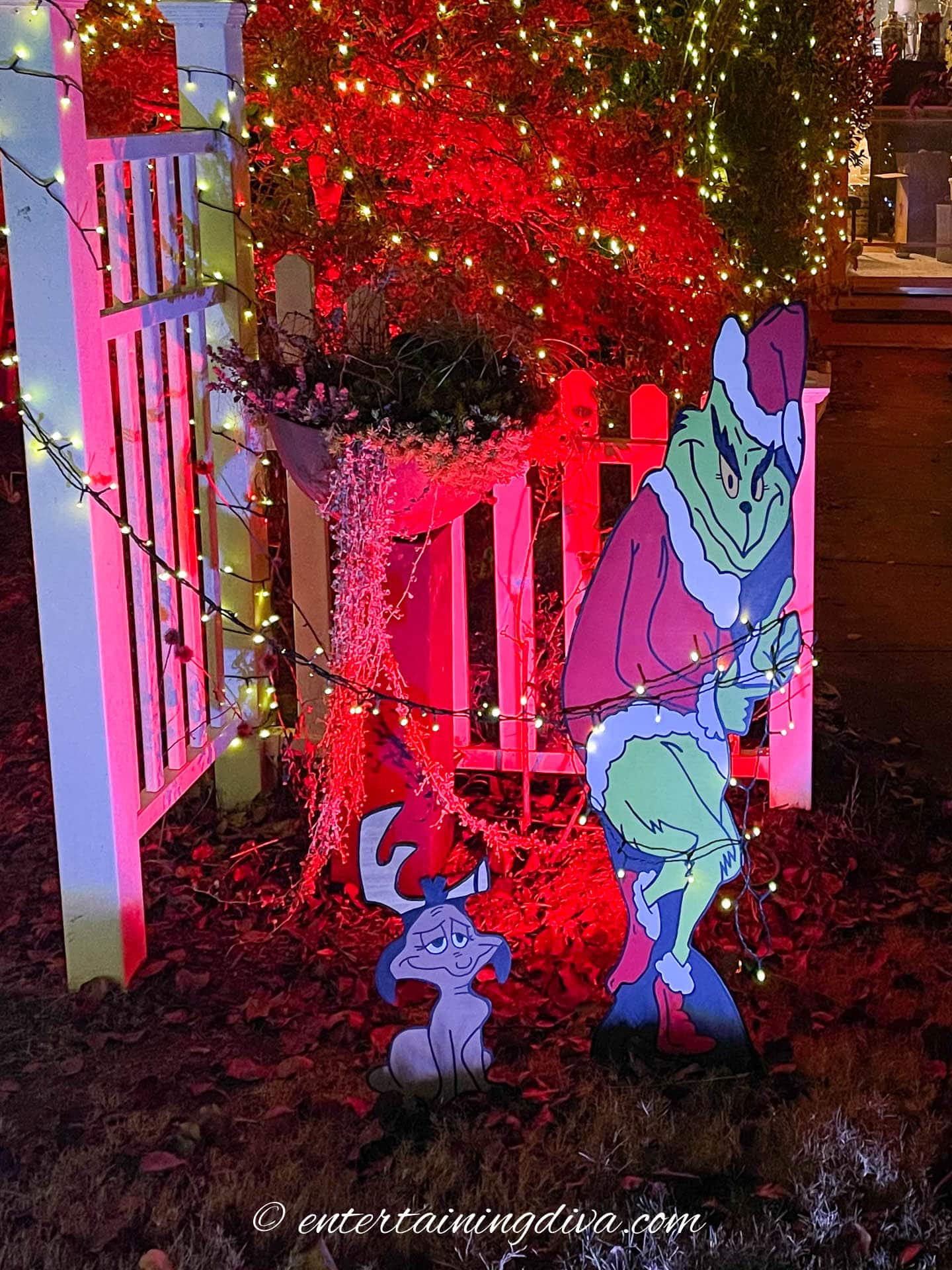 Grinch stealing lights off an arbor with Max by his side