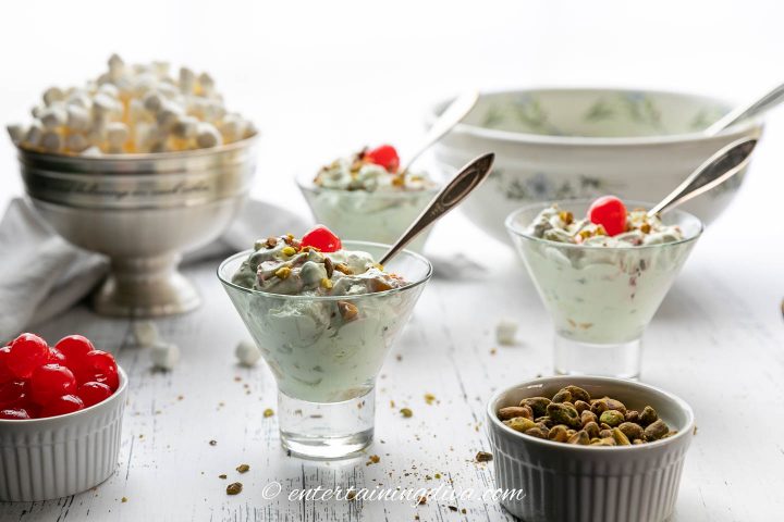 Three dishes of pistachio fruit salad with spoons