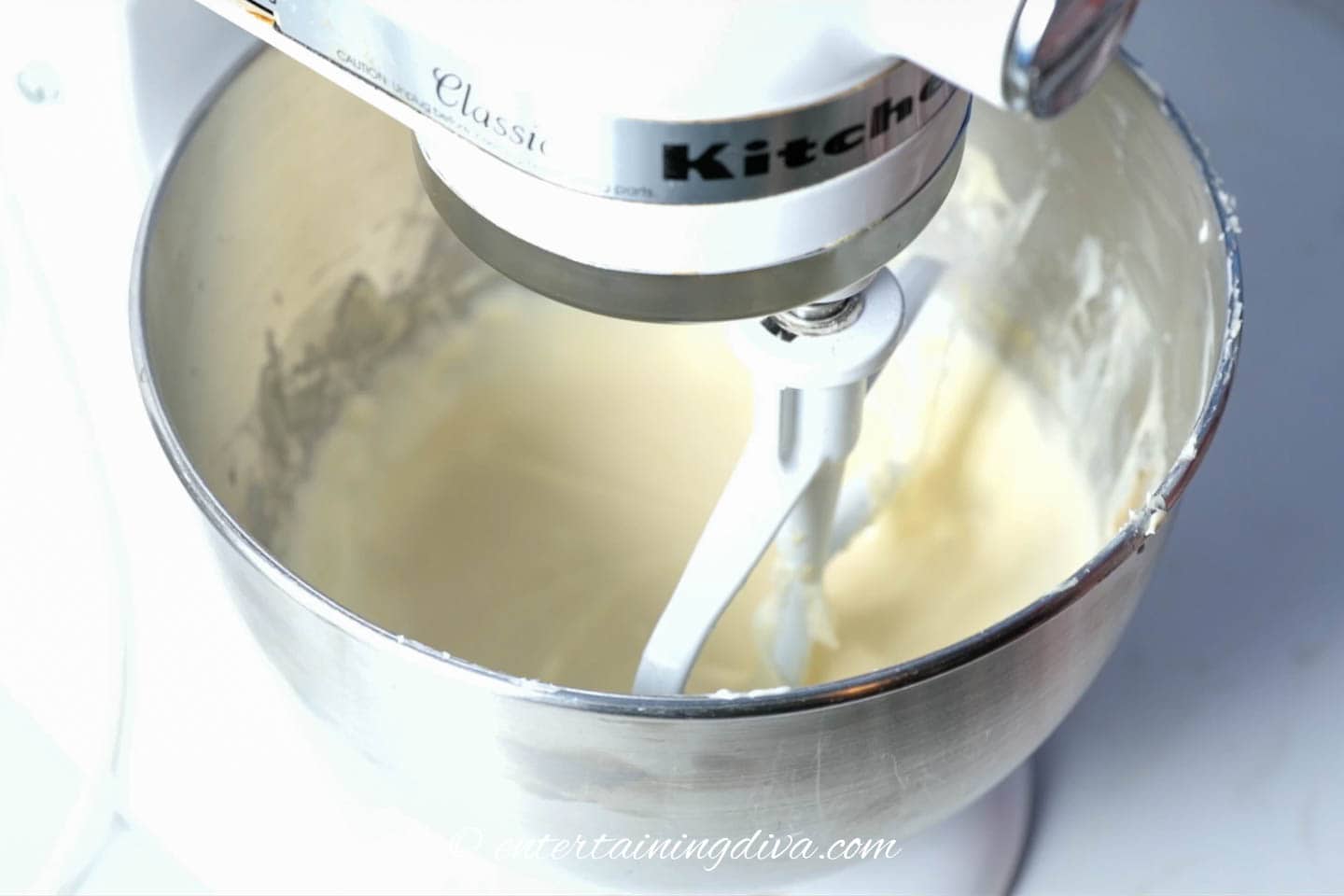 Cheesecake batter being mixed in a mixer
