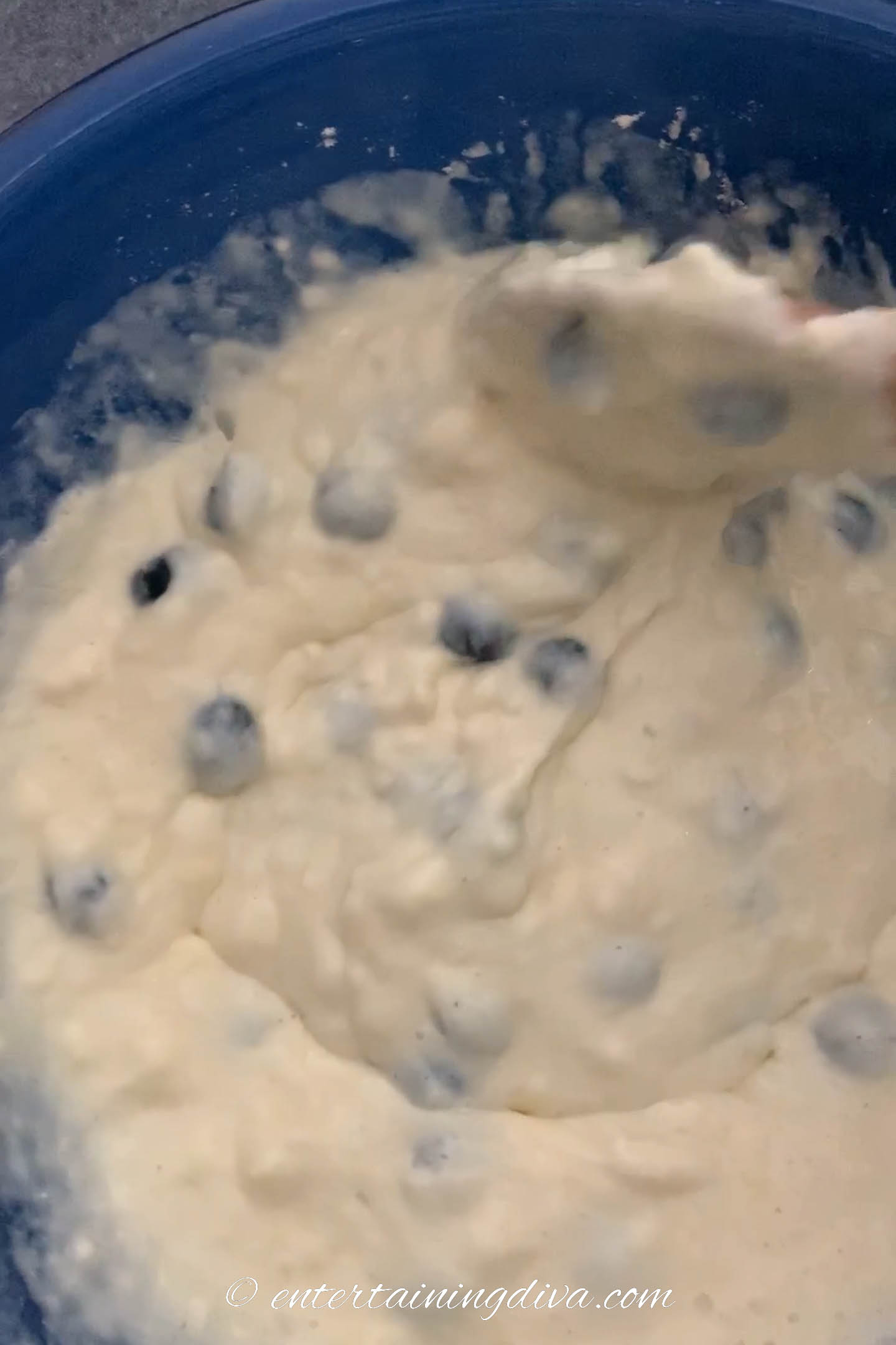 blueberries being stirred into the pancake batter