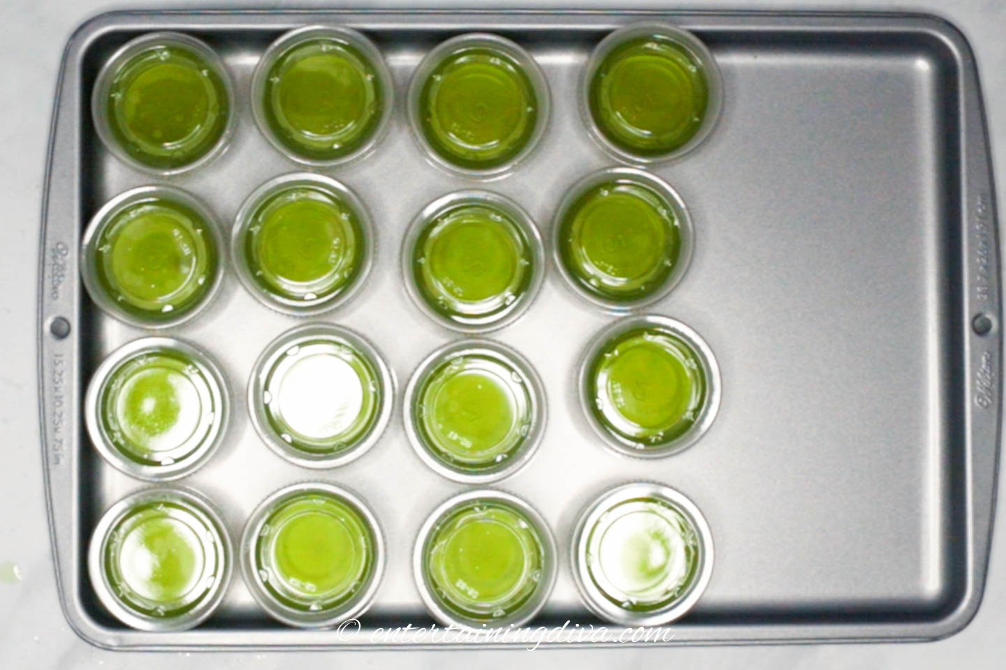 Green apple cinnamon fireball gelatin shots on a cookie sheet