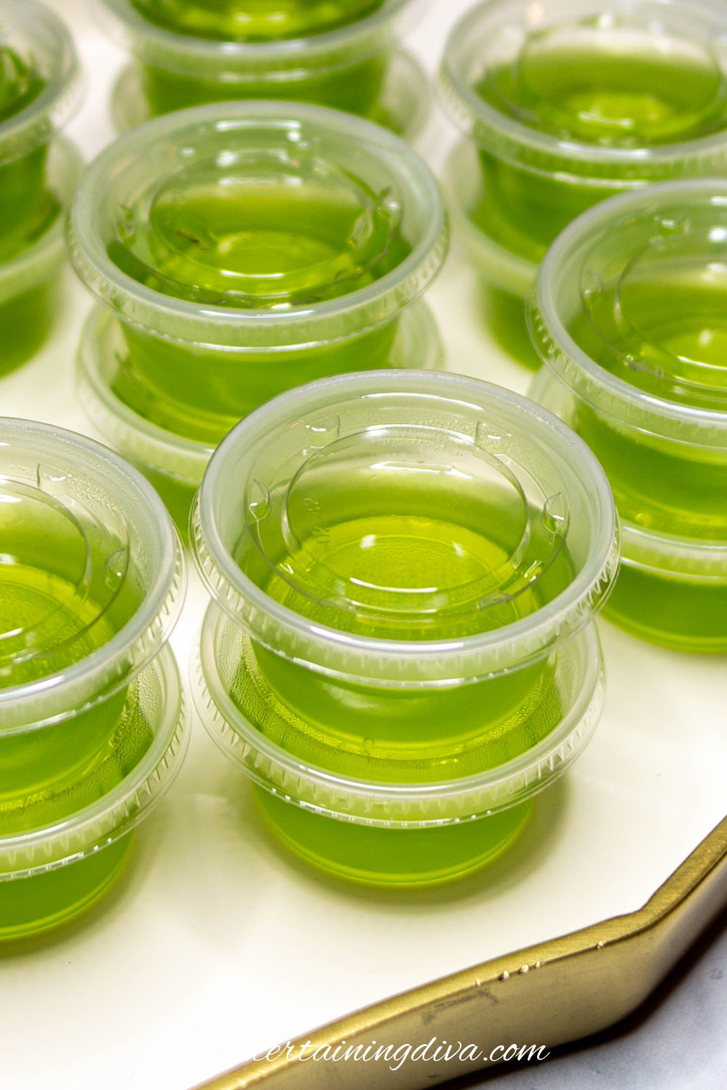 stacks of green apple cinnamon gelatin shots in shot cups with lids