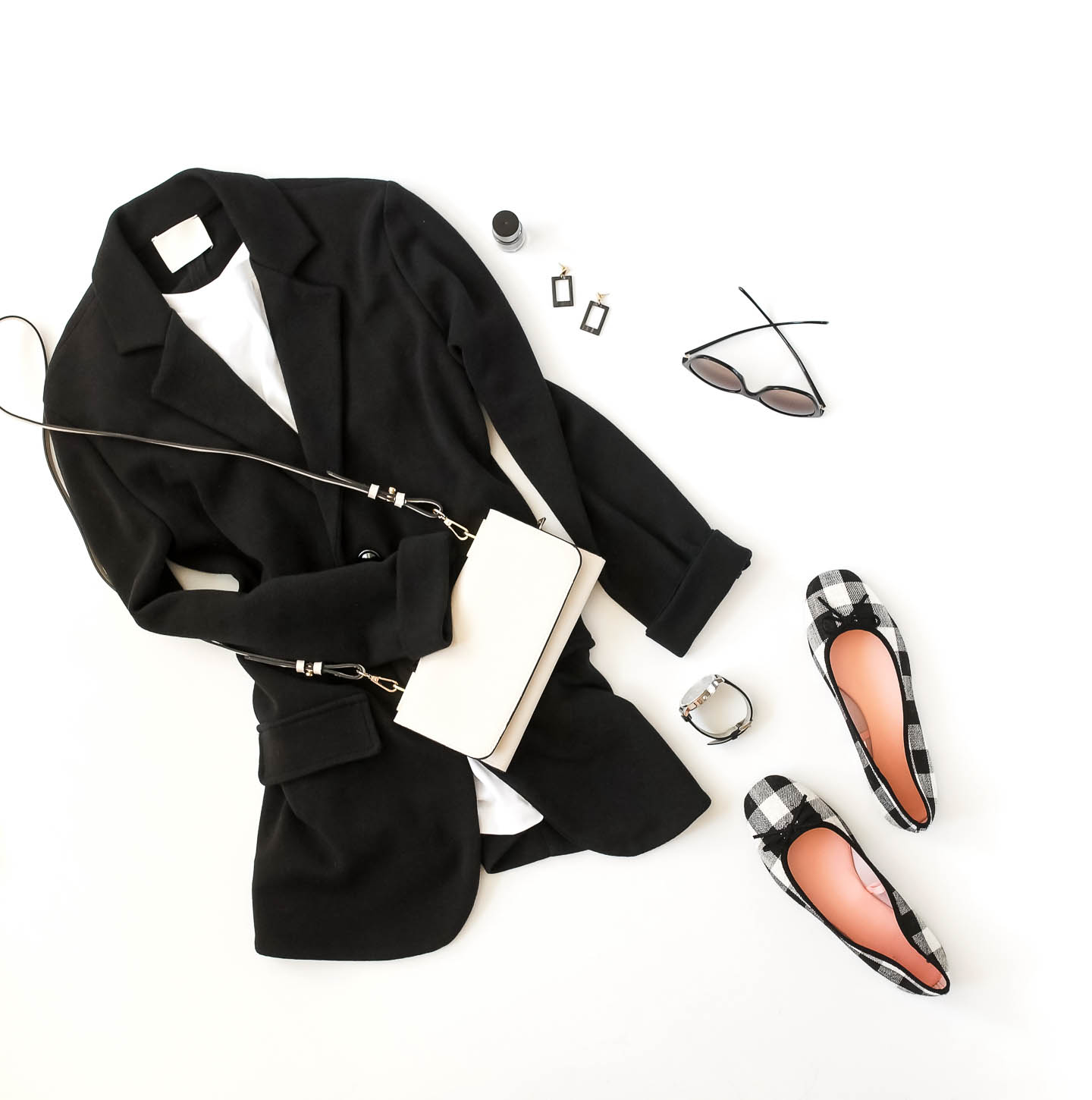 black and white outfit flat lay with a white purse and black and white shoes