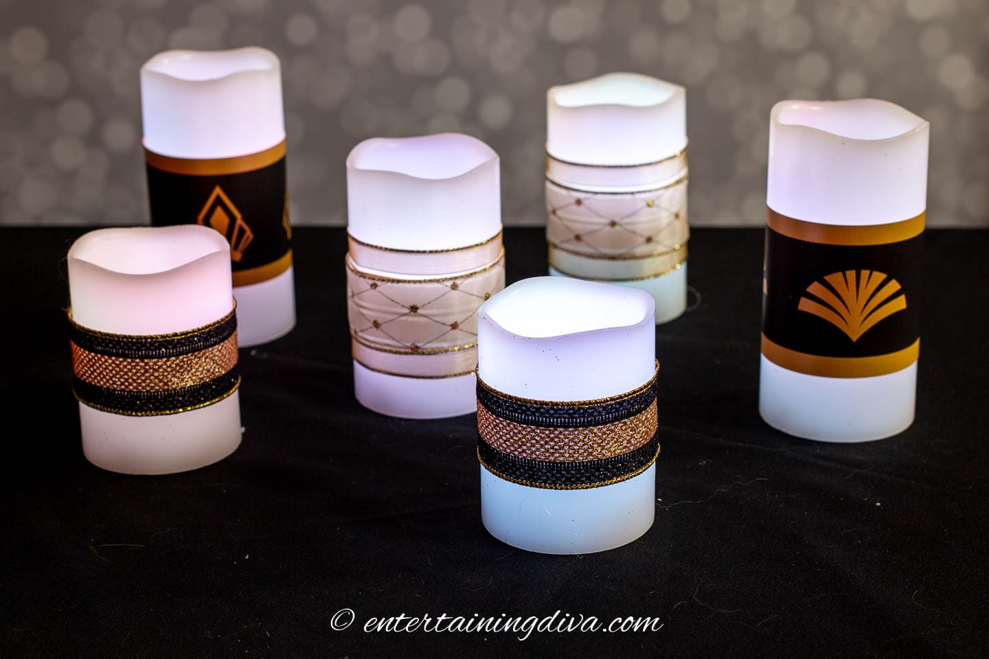 flameless pillar candles decorated with white, gold and black ribbon