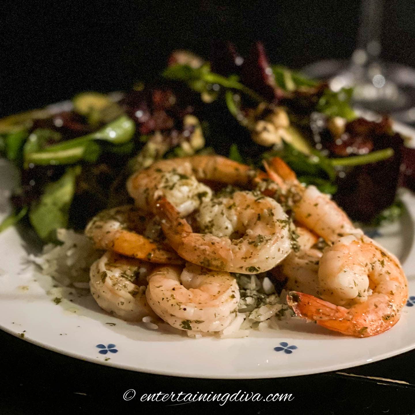 lemon garlic butter shrimp on a plate with salad