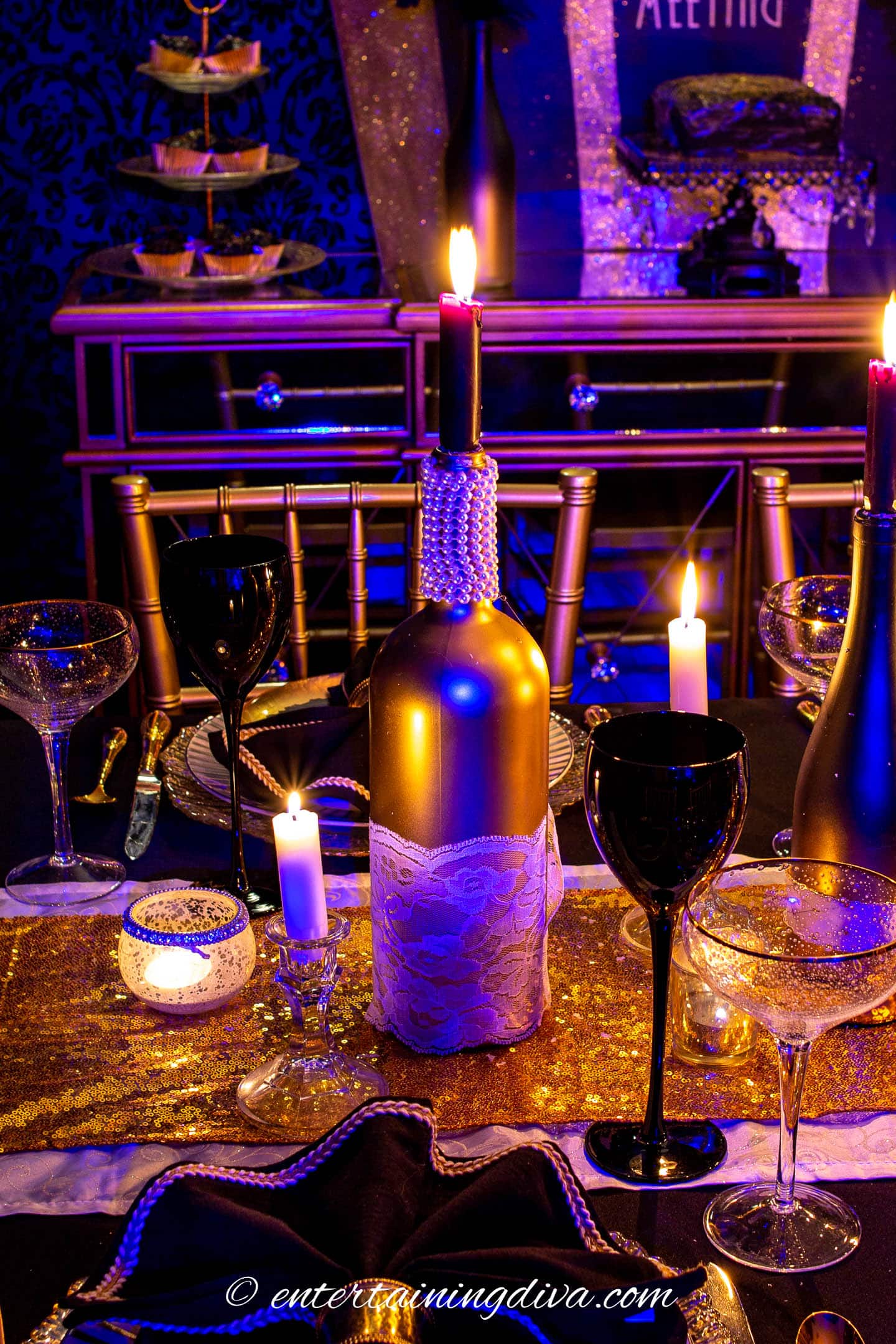 elegant pearls and lace gold wine bottle centerpiece on a black and gold tablescape