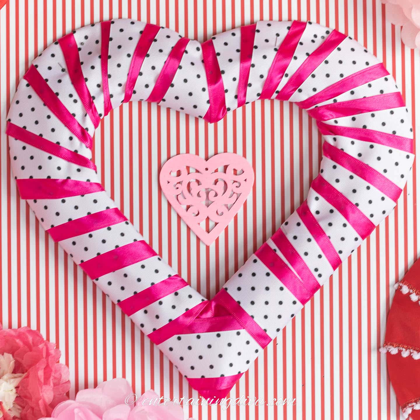 DIY heart wreath made from bright pink ribbon layered with white and black ribbon