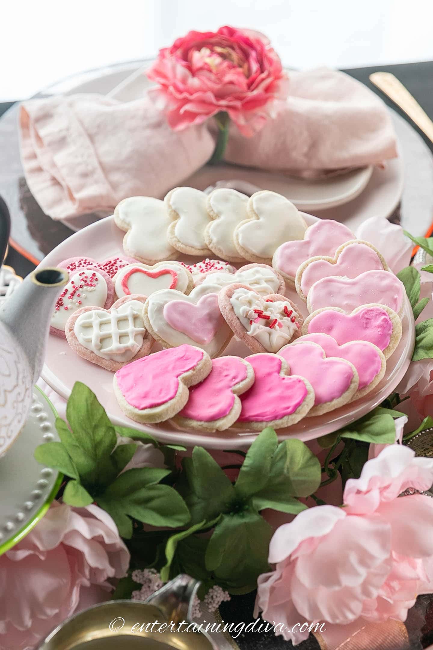 Pink heart shaped sugar cookies on a cake stand