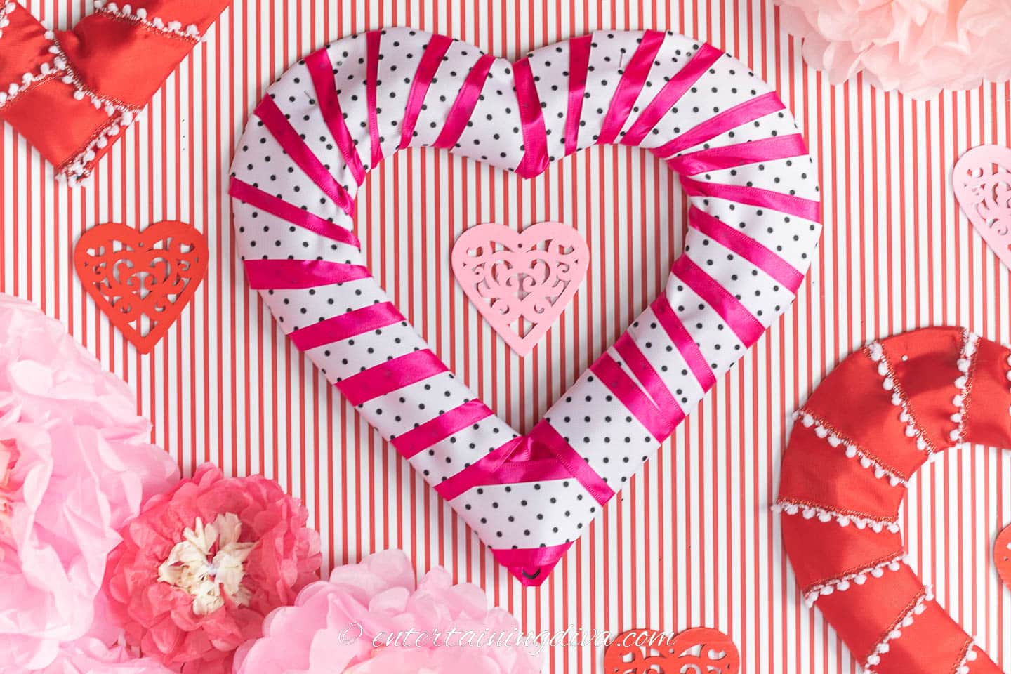 DIY pink, white and black heart wreath on a wall with red and white stripes