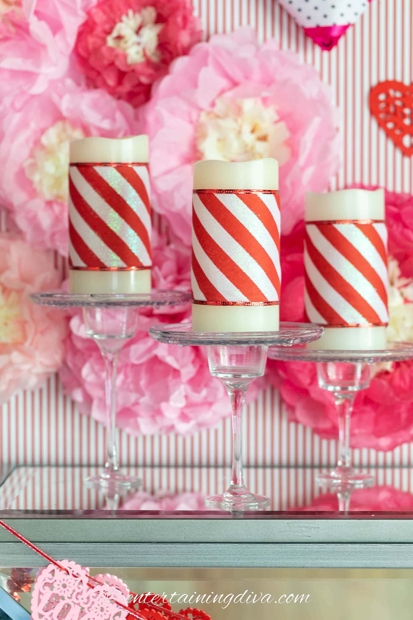Pillar candles decorated with red and white striped ribbon