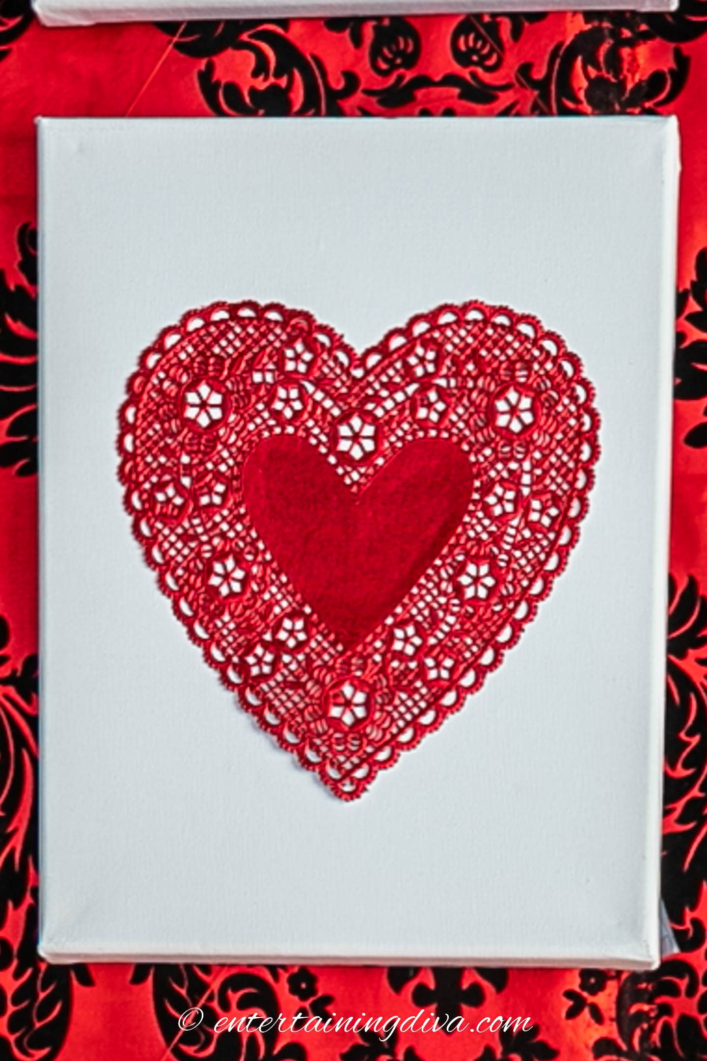 Red doily heart on a white canvas background