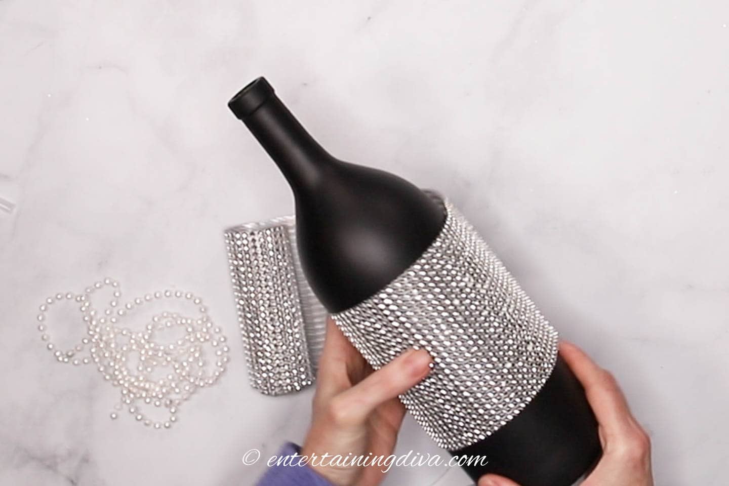 Rhinestone ribbon wrapped around the middle of a wine bottle