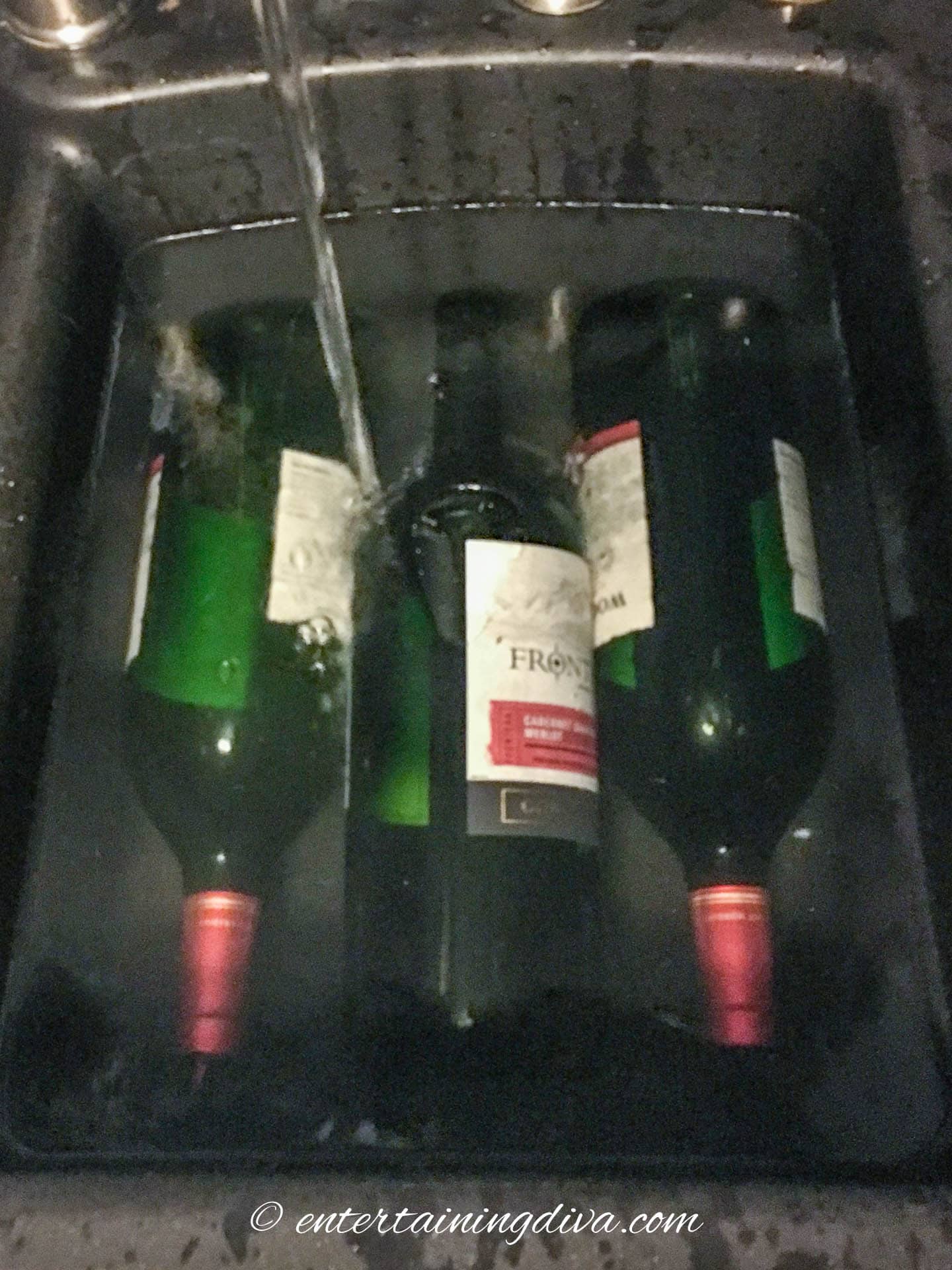 wine bottles soaking in water in a sink
